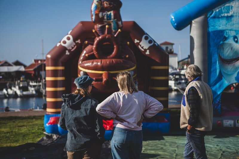 Besökare framför en hoppborg i piratform vid hamnen